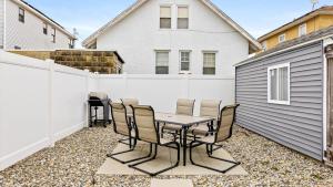 a patio with a table and chairs and a fence at Modern Beach Retreat Sleeps 8 - Big Yard & BBQ in Ventnor City +22 photos