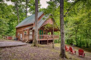 a log cabin in the woods with red chairs at Pine Ridge in Sevierville