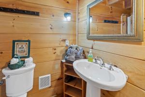 a bathroom with a sink and a toilet and a mirror at Pine Ridge in Sevierville +34 photos