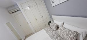a bedroom with a white bed with pillows on it at The Hideaway 2 Bed Poolside Groundfloor Apartment On Albatros Full AC Free Fast Wifi in Los Alcázares