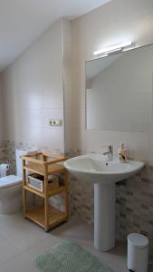 a bathroom with a sink and a mirror and a toilet at Cantiño 39 in Lugo