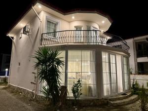 Una casa blanca con un balcón encima. en Villa Derin, en Okçular