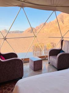 ワディ・ラムにあるRum Royal Dunes Camp & tourの砂漠の景色を望む客室で、椅子2脚とベッド1台が備わります。 +92枚の写真