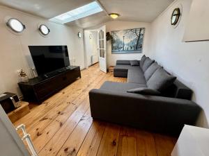 a living room with a couch and a flat screen tv at Prague on Boat, Privat Pier, Free Parking in Prague