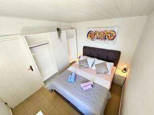 a small bedroom with a bed with two pillows at Apartments Liana - VaLa in Mimice +60 photos