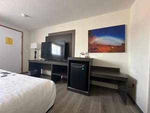 una camera d'albergo con scrivania, TV e letto di Hotel 191 - Moab a Moab