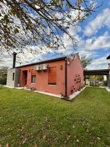 a small pink building with a grass yard at La Mora Home - Casa de Campo in Victoria +23 photos