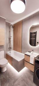 a bathroom with a tub and a toilet and a sink at Rumia Cichy Zaułek 2 in Rumia