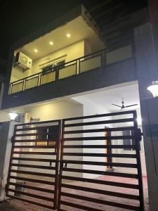 a house with a balcony with a gate and a fence at The Boutique Homestay in Raipur in Raipur