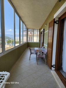 a balcony with a table and chairs and windows at Villa Arilena in Sarandë