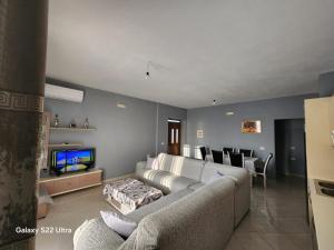 a living room with a couch and a tv at Villa Arilena in Sarandë