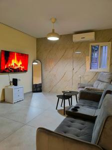 a living room with two couches and a fireplace at Coastal Comfort in Haifa