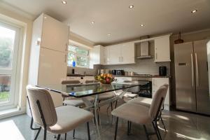 a kitchen with a table and chairs and a refrigerator at Free Parking 6 Beds Fully Equipped Home Favourite by Contractors & Groups in Earley