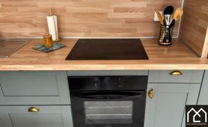 a kitchen with a black oven and a wooden counter at Maison Cocooning Equihen 5 pers Proche Mer & Terrasse in Équihen-Plage