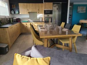 ChâteauthébaudGîtes L'Infinity - 4 Chambres的厨房里有一张木桌和黄色的椅子 更多13张照片