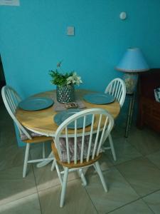 uma mesa de madeira com quatro cadeiras e pratos azuis sobre ela em Free pickup from Rodney Bay Marina em Gros Islet
