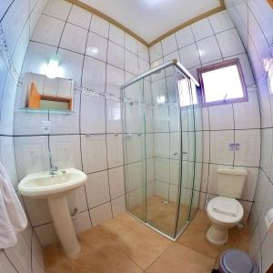 une salle de bain avec une douche, des toilettes et un lavabo dans l'établissement Pousada Deus é Fiel, à Cachoeira Paulista