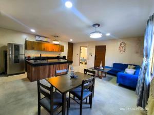 a living room with a table and a blue couch at Agua Azul Chicxulub Puerto in Chicxulub