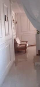 a hallway with a door and a chair in a room at bikla f3 2nd floor in Khenchela +1 photo