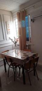 a dining room table with a vase with flowers on it at bikla f3 2nd floor in Khenchela
