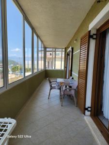 a balcony with a table and chairs and windows at Villa Arilena in Sarandë +13 photos
