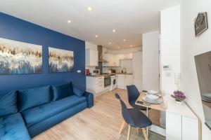 a living room with a blue couch and a table at Large Groups Stays 12 Beds Whole Building in Reading