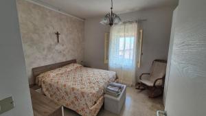 ein kleines Schlafzimmer mit einem Bett und einem Stuhl in der Unterkunft Casa dolce Casa in Cologna