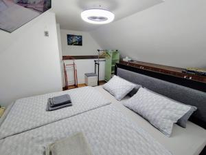 a bedroom with a white bed with two pillows at In the Green in Lopatinec