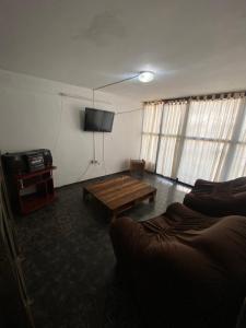 un salon avec une table et une télévision dans l'établissement Departamento sobre la López Torres, à Posadas