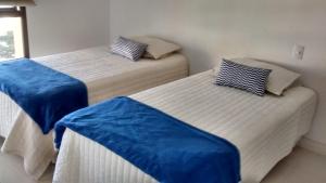 two beds in a room with blue covers on them at Apartamento 2 quartos no Leblon Com Varanda e Vista para o Mar in Rio de Janeiro