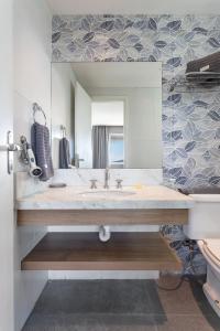 ein Badezimmer mit Waschbecken und Spiegel in der Unterkunft Verano Stay Barra Olímpica in Rio de Janeiro