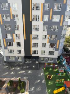 a large apartment building with a playground in front of it at Замечательная новая квартира на Ботанике in Chişinău