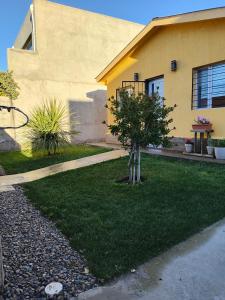 a house with a small tree in the yard at Kaike in Caleta Olivia