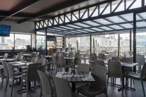 a dining room with tables and chairs and windows at Hotel Principal in Mexico City