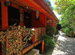 un edificio rojo con plantas delante de él en Adriana's Place Tropical Guesthouse, en Panglao