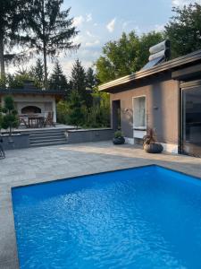 a blue swimming pool in front of a house at Villa Pazaric in Resnik