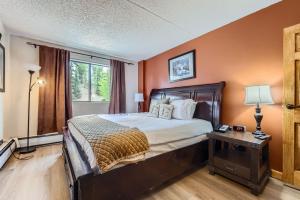 a bedroom with a bed with an orange wall at Beaver Run 1 Bedroom Condo in Breckenridge