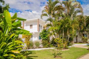 a white house with palm trees in front of it at Hotel Casa Pierretta in Las Terrenas