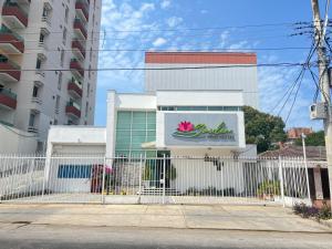 a white fence in front of a building at Garden Home Hostal in Barranquilla