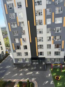 an apartment building with a playground in front of it at Комфортная квартира на Ботанике in Chişinău