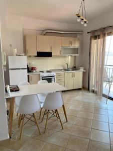 a kitchen with a table and chairs in a room at Alexis Apartments in Pylos