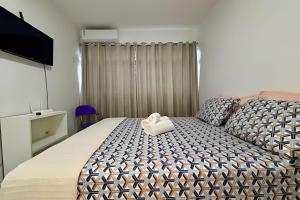 Un dormitorio con una cama grande con asiento en forma de corazón. en Summer Park Bloco H, en Brasilia