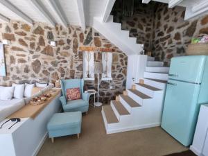 a living room with stairs and a stone wall at 65 Stairs Τo Ηeaven Private Pool in Áno Meriá