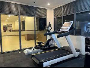 a room with a gym with a treadmill and a laptop at R2N Cosy Haven - BE Residences Lahug near IT Park Cebu in Cebu City