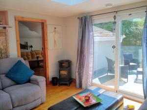 a living room with a couch and a sliding glass door at Cosy Rural Gilbert Hights Llandovery Cynghordy in Cynghordy