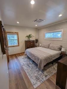 a bedroom with a bed and a dresser and two windows at The Perfect Pair, Cozy Cottage Lakeside & Hillside Hangout for Large Groups in Pinetop-Lakeside