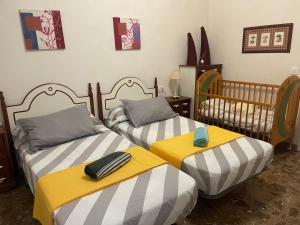 una camera da letto con due letti singoli con lenzuola gialle e grigie di Acogedora planta baja a Benaguacil
