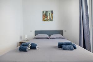 a bedroom with a bed with blue pillows on it at The Apateu in St Paul's Bay