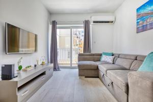 a living room with a couch and a tv at The Apateu in St Paul's Bay