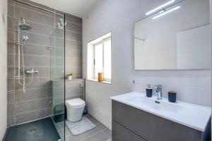 a bathroom with a sink and a glass shower at The Apateu in St Paul's Bay +28 photos